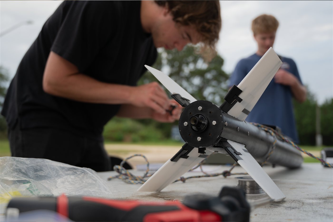 Team member fitting a fin tab to Moonfall on a work table