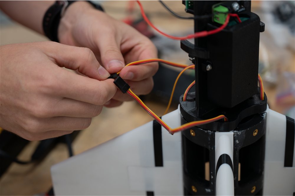 Hands connecting an actuator lead near the aft hub